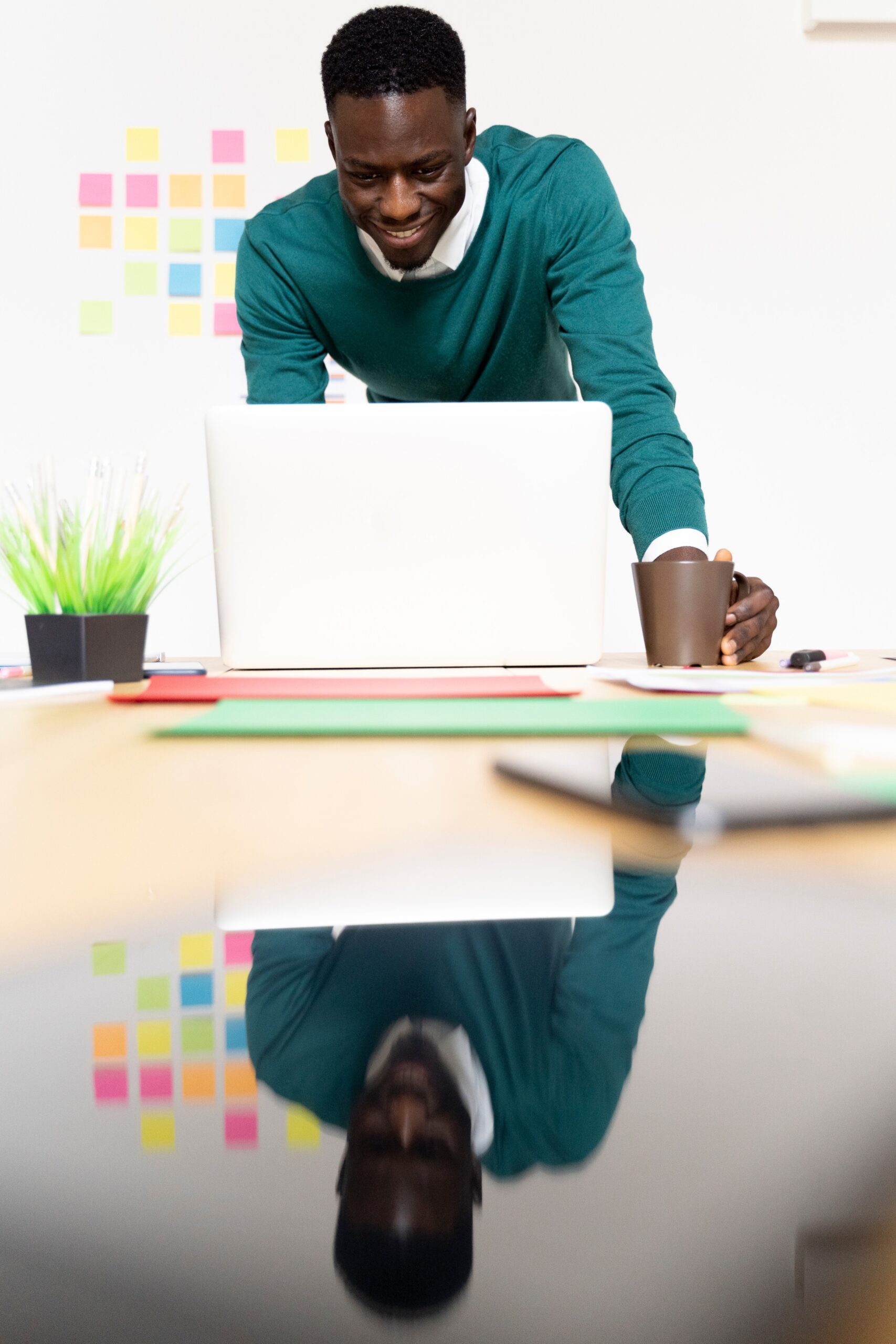 smiling-man-working-on-laptop-at-desk-in-office
